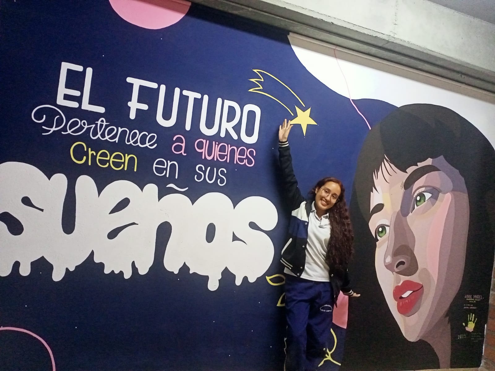 La egresada Ashlye María Muriel posando al lado de su obra.